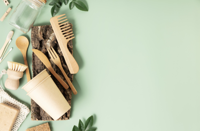 A collection of sustainable, eco-friendly products like wooden utensils and reusable containers on a green background. Perfect for retirees focusing on sustainability within their nomadic lifestyle.