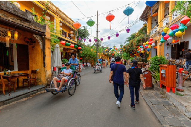 A vibrant street market in Southeast Asia, adorned with colorful lanterns and bustling with activity. Captures the spirit of exploration and cultural experiences.