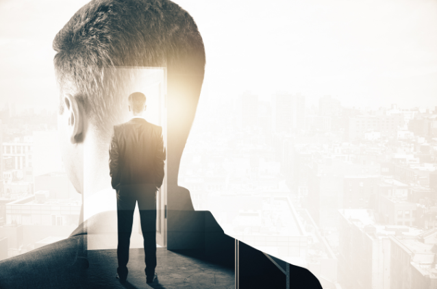 Creative double exposure of a man standing with a bright doorway superimposed over a cityscape, symbolizing new opportunities and growth.