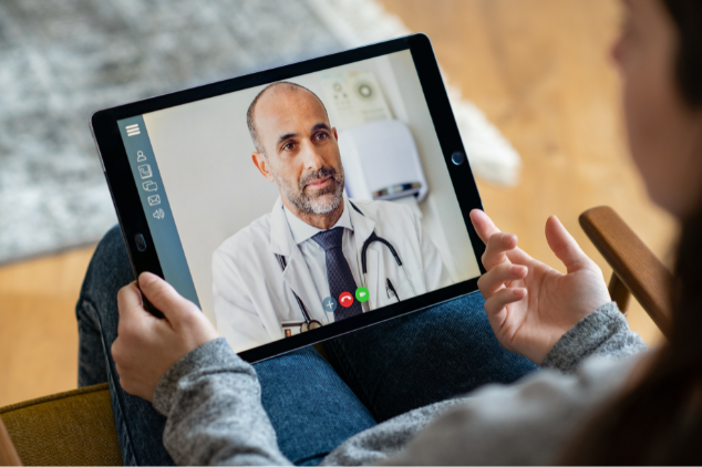 : A woman using a tablet for a telemedicine appointment, showcasing the integration of health management in digital nomad retirement planning.