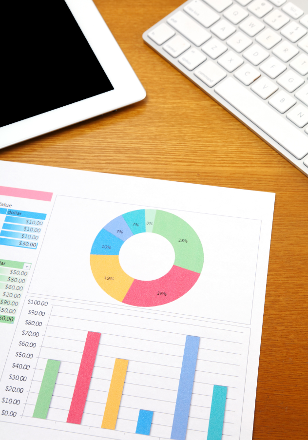 Colorful financial graphs and charts on a desk with a tablet and keyboard, illustrating tools for tracking retirement savings.