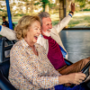 An energetic older couple joyfully riding bumper cars.