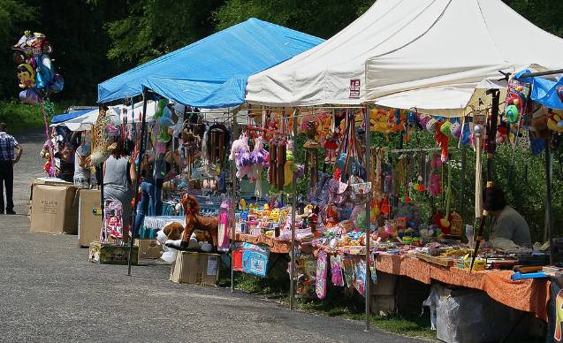 A bustling outdoor market with vendors selling handmade goods, illustrating a way to monetize hobbies.