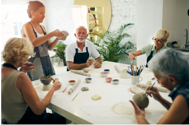 A group of retirees in a pottery workshop, emphasizing the value of lifelong learning, creativity, and social engagement.