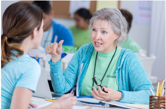 A dedicated older woman engaging in conversation while volunteering.