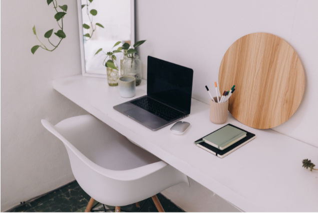 A minimal home office setup with a laptop and notebook, emphasizing the low startup costs of consulting after 50.