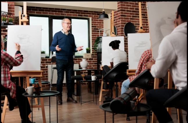 An elderly man teaching a drawing class in a cozy art studio, showing how hobbies and group activities can help retirees maintain social connections and combat loneliness in retirement.