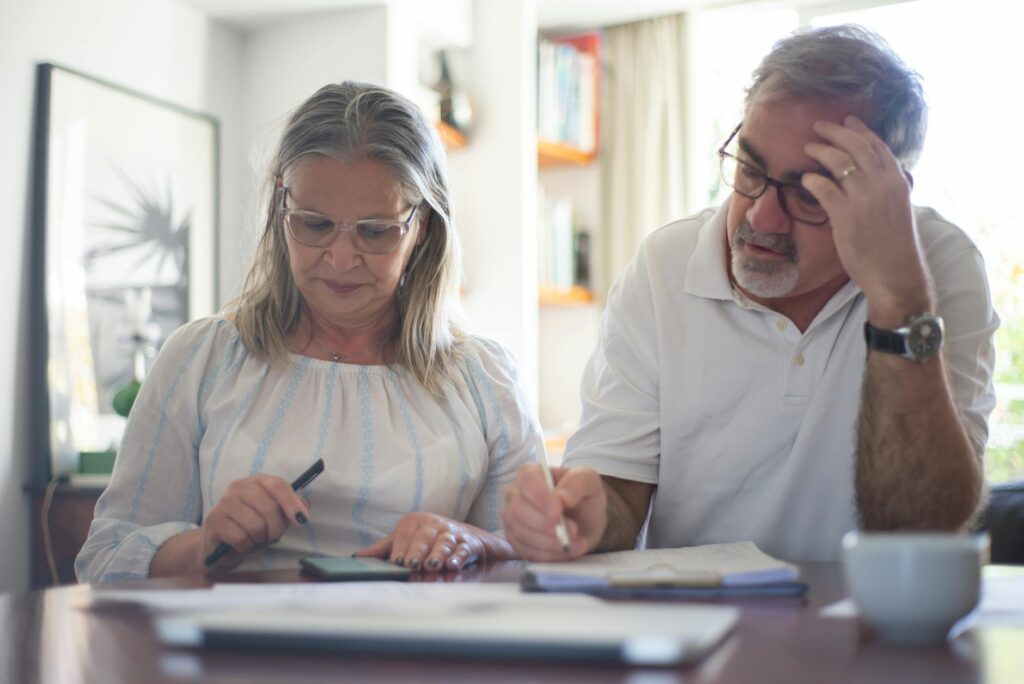 Retired couple sitting at table discussing finances and income strategy